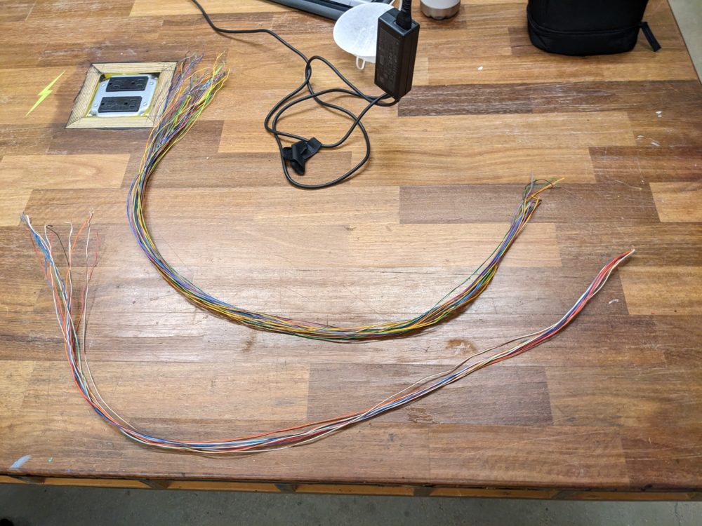 Two bundles of wires, separated into colorful sections that form the trunk and roots of the tree